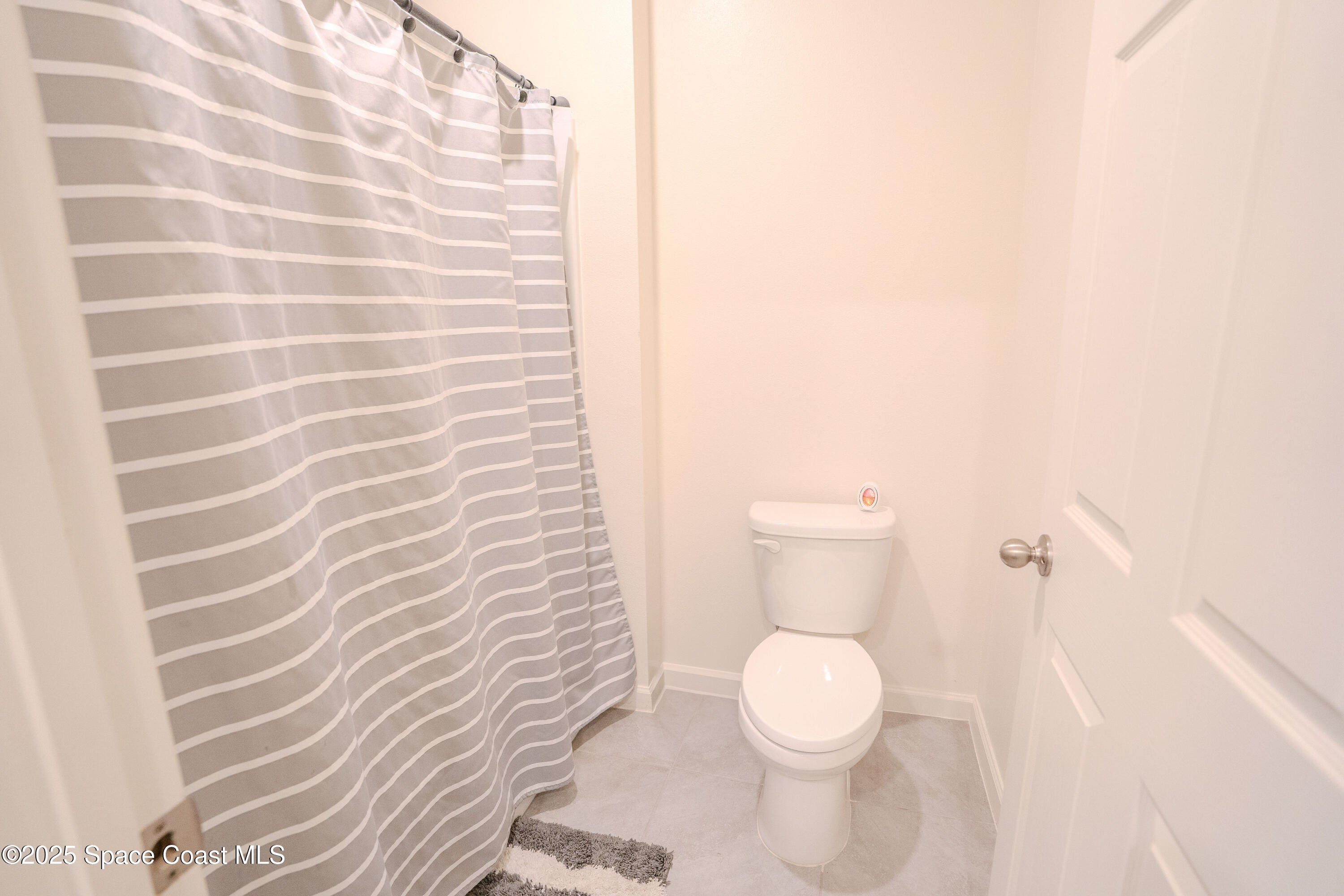 3409 Burrowing Owl Mims, FL 32754 - Photo 29 of 36 a white toilet sitting next to a shower curtain