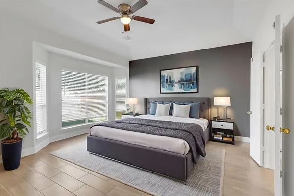 a spacious bedroom with a large bed and a potted plant