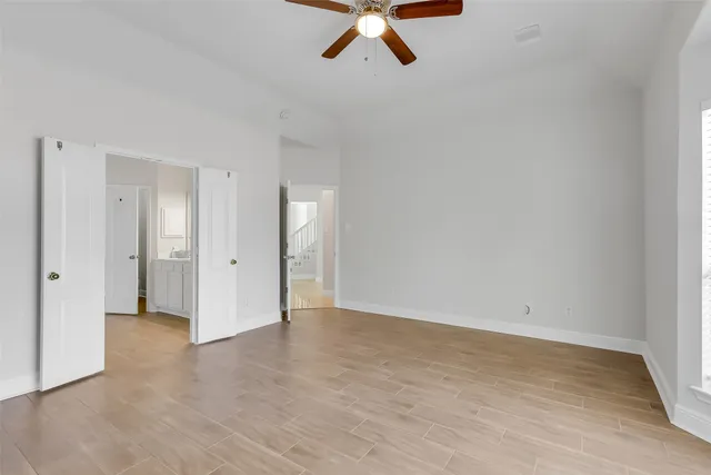 a view of room with hardwood floor and ceiling fan
