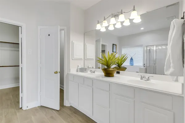 a bathroom with a double vanity sink and a mirror