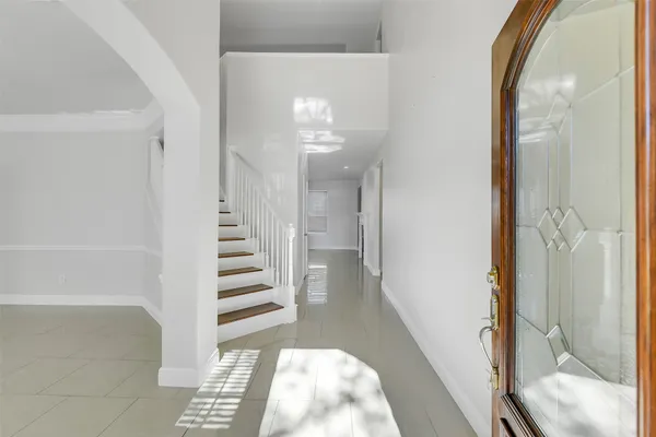a view of a hallway with wooden floor and staircase