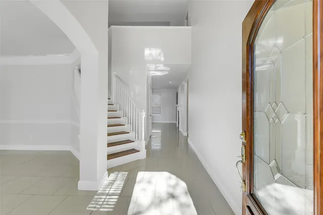 a view of a hallway with wooden floor and staircase