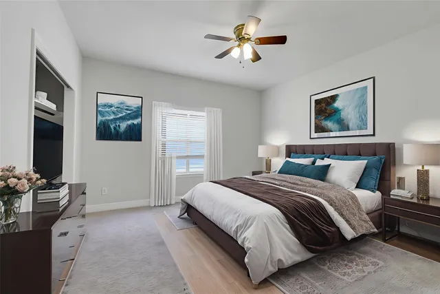 a spacious bedroom with a large bed and a chandelier