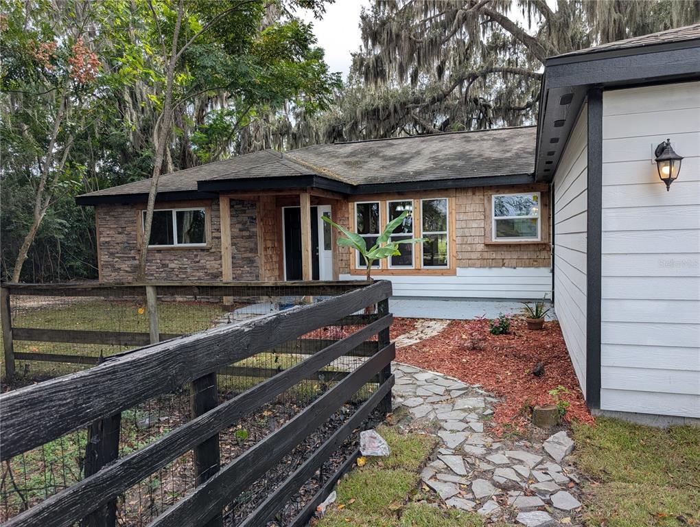 12022 Southeast Sunset Harbor Road Weirsdale, FL 32195 - Photo 2 of 17 a front view of a house with garden