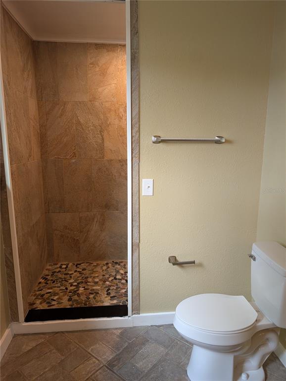 12022 Southeast Sunset Harbor Road Weirsdale, FL 32195 - Photo 9 of 17 a bathroom with a shower and a toilet