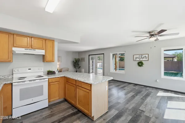 a kitchen with stainless steel appliances granite countertop a sink stove and cabinets
