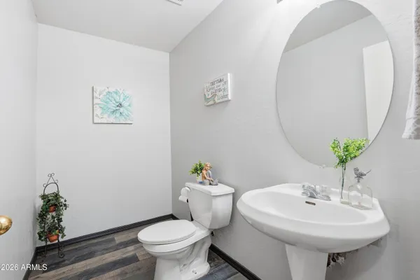 an empty room with wooden floor mirror and windows