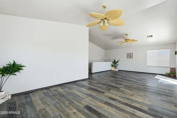 a view of an empty room with a window and a chandelier fan