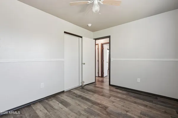 an empty room with windows and ceiling fan