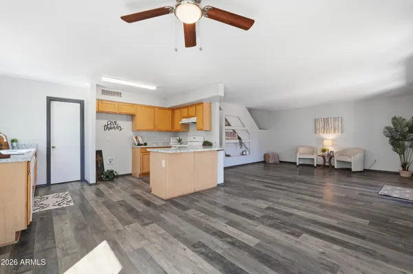 a kitchen that has a lot of cabinets in it and wooden floor