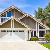 a view of a house with a yard and potted plants
