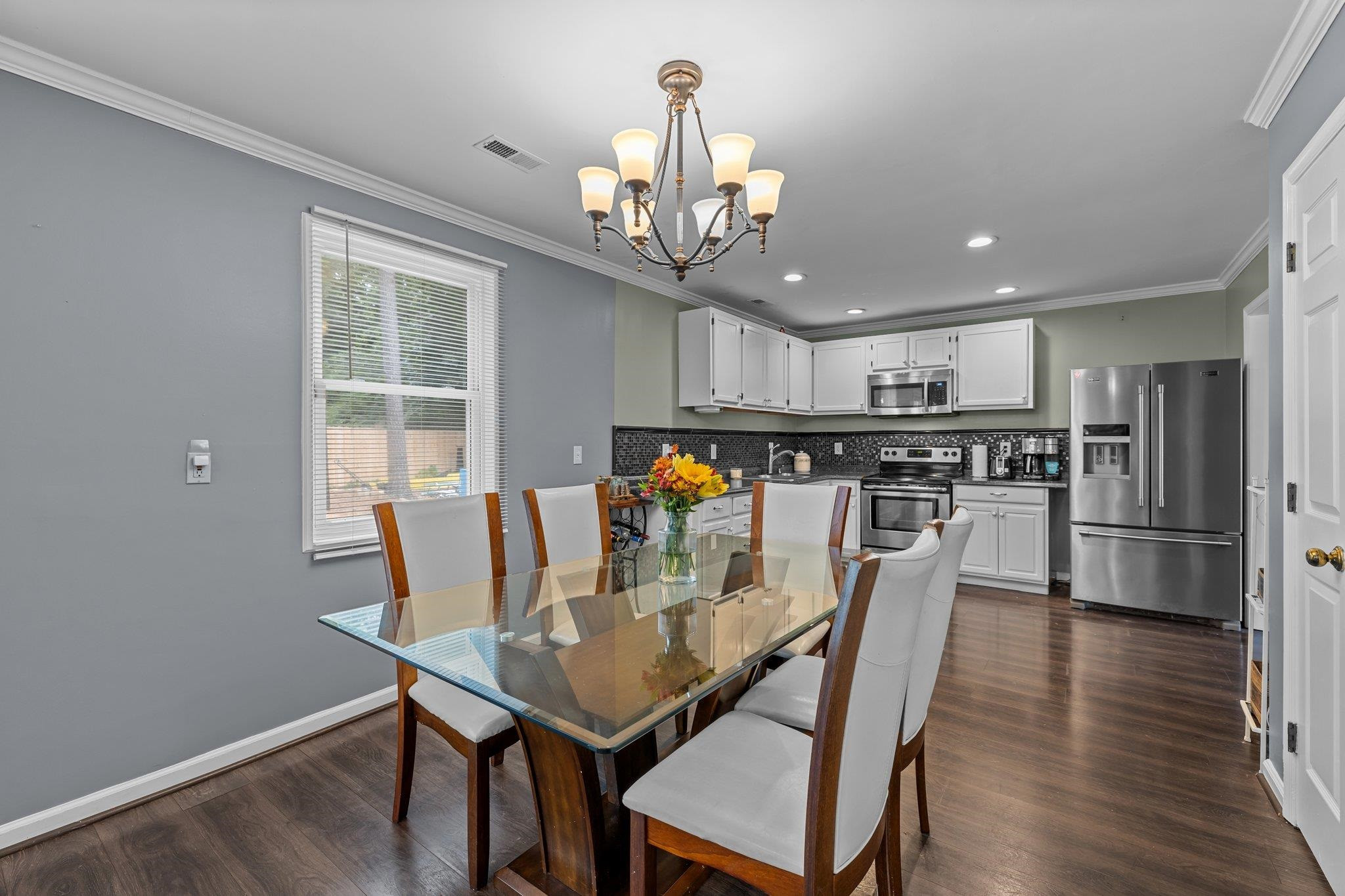 2208 Dobbin Place Raleigh, NC 27604 - Photo 14 of 42 a view of a dining room with furniture a chandelier and wooden floor