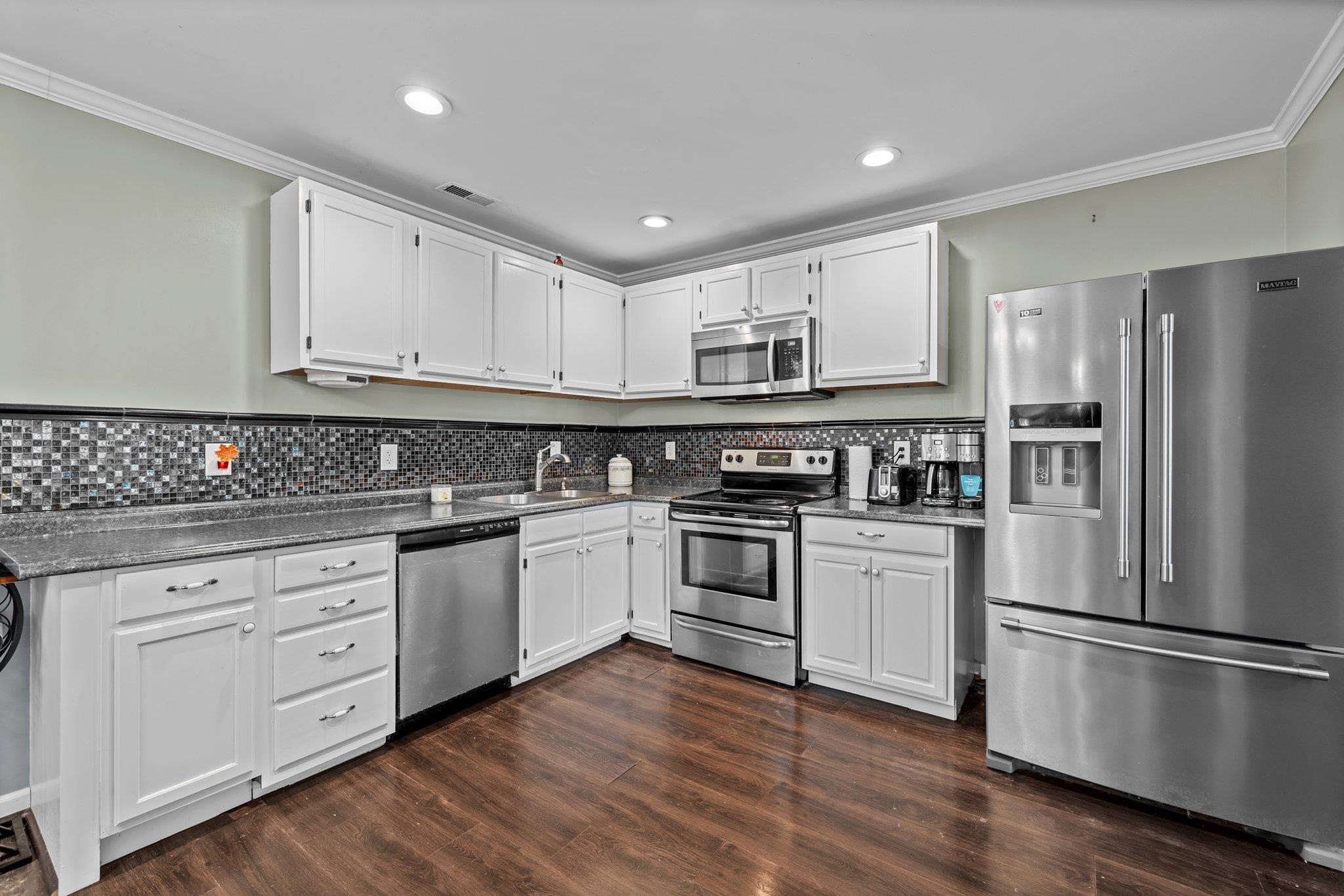 2208 Dobbin Place Raleigh, NC 27604 - Photo 10 of 42 a kitchen with stainless steel appliances granite countertop a refrigerator and a stove top oven