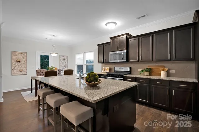 a view of a dining room with furniture a rug and wooden floor