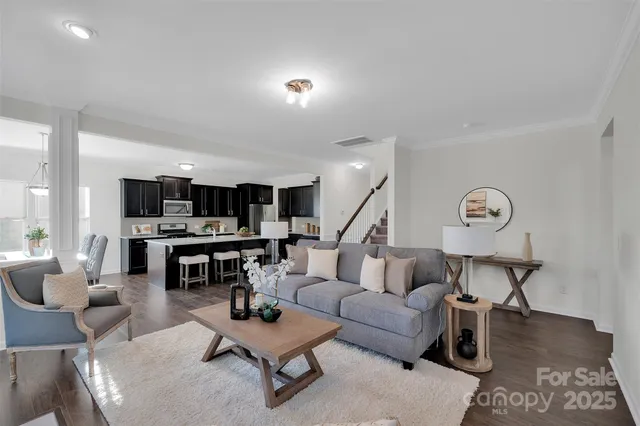 a living room with furniture and view of kitchen