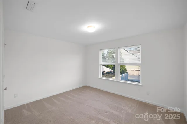 a view of a hallway with wooden floor and a living room