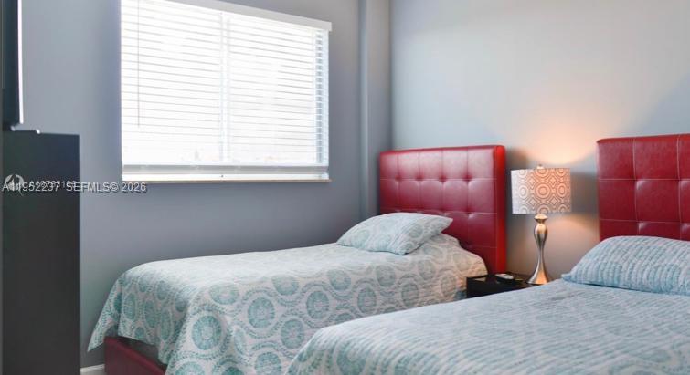 2280 Southwest 32nd Avenue, Unit 613 Miami, FL 33145 - Photo 8 of 15 a bedroom with two beds and a window