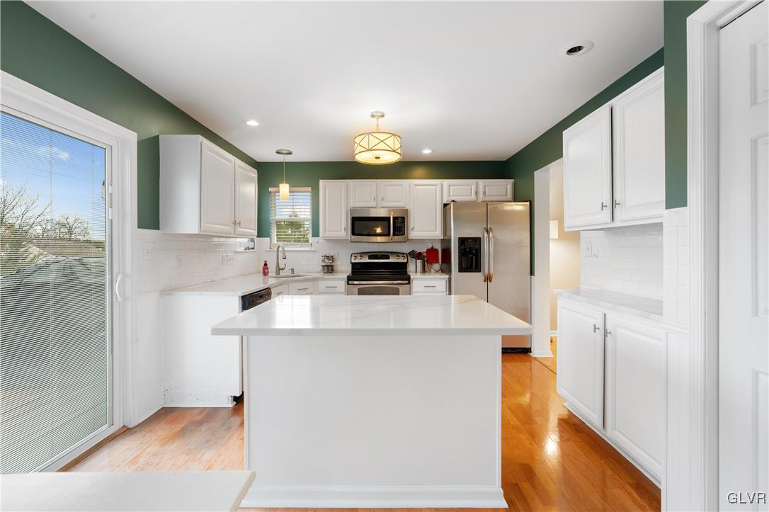 2229 Juniper Drive Coplay, PA 18037 - Photo 13 of 52 a kitchen with stainless steel appliances a microwave a stove a refrigerator a sink and white cabinets with wooden floor
