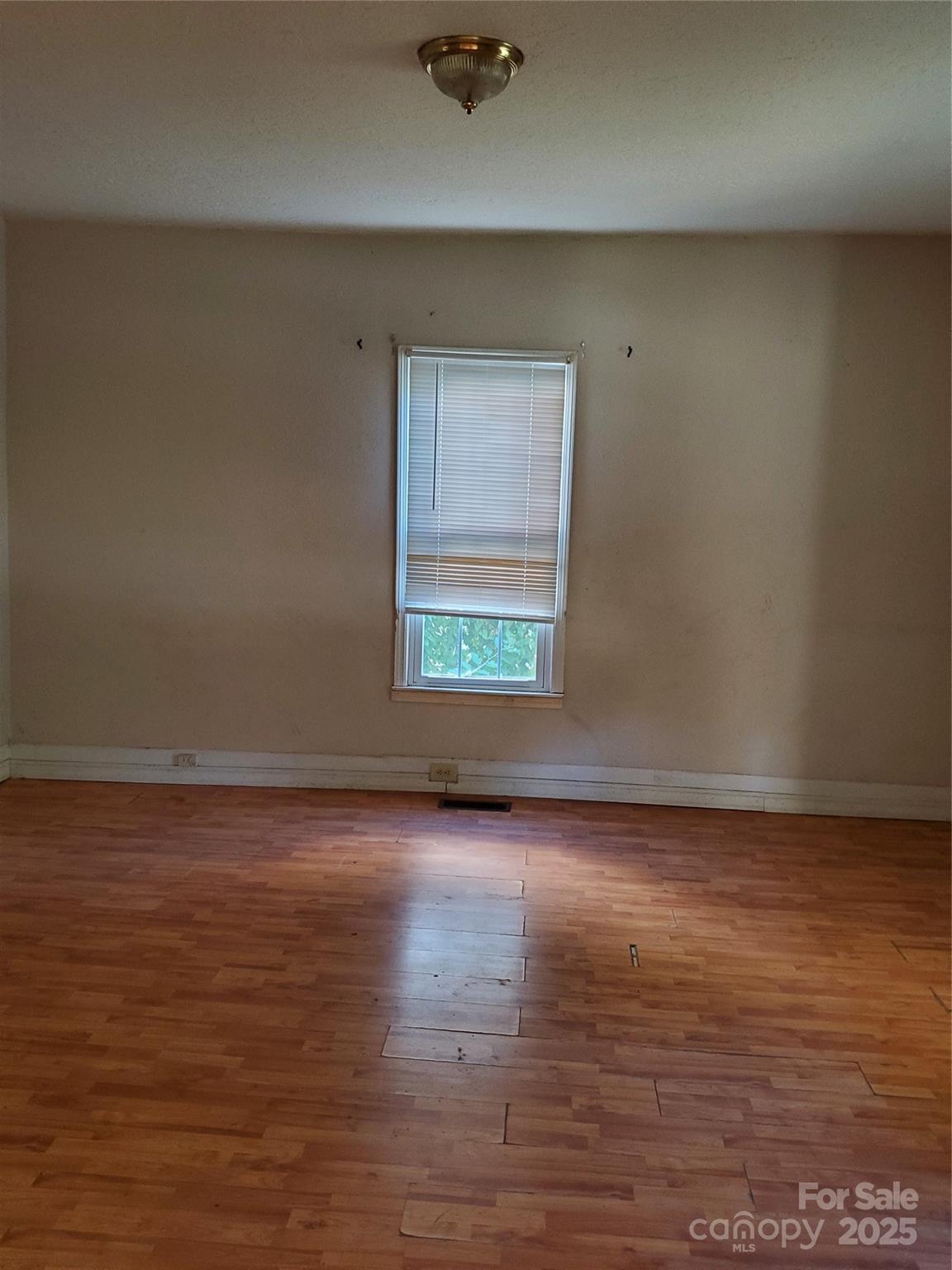 414 South Rowan Avenue Spencer, NC 28159 - Photo 6 of 15 an empty room with wooden floor and windows