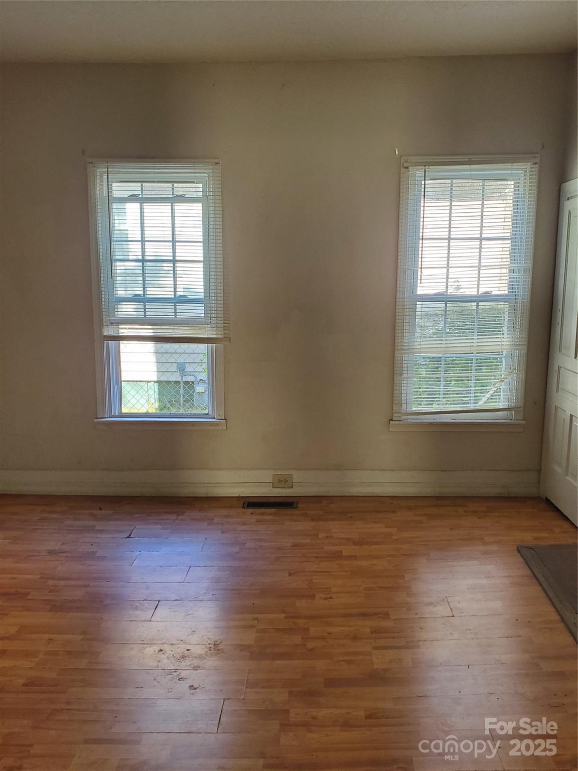 414 South Rowan Avenue Spencer, NC 28159 - Photo 8 of 15 an empty room with wooden floor and windows