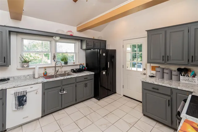 a kitchen with granite countertop appliances cabinets and a sink