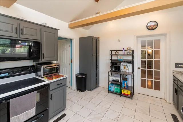 a view of a kitchen with fridge and windows