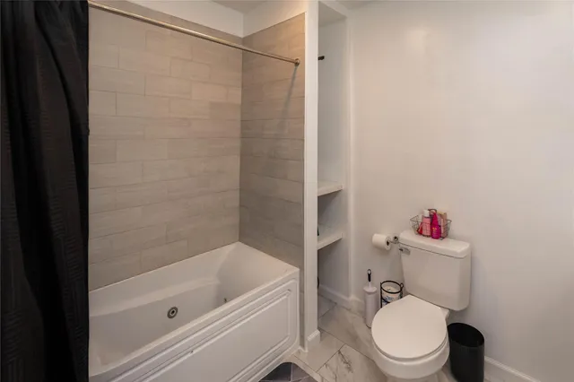 a white toilet and tub sitting next to a bathroom sink