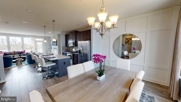 a living room with dining table and a chandelier
