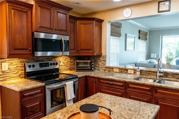a kitchen with stainless steel appliances granite countertop a sink stove and cabinets
