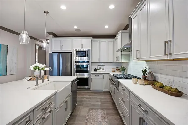 a view of an empty room with wooden floor and fan