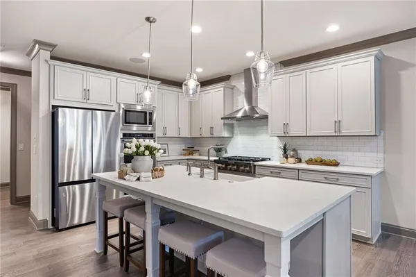 a kitchen with stainless steel appliances a stove a refrigerator a sink and a refrigerator