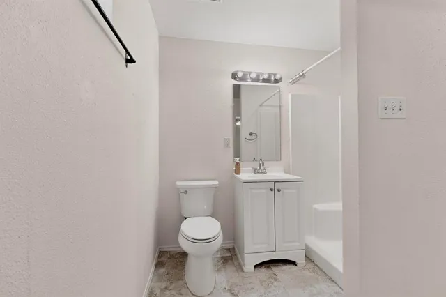 a view of an empty room with wooden floor and closet