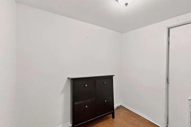 a view of a backyard with wooden fence and large trees