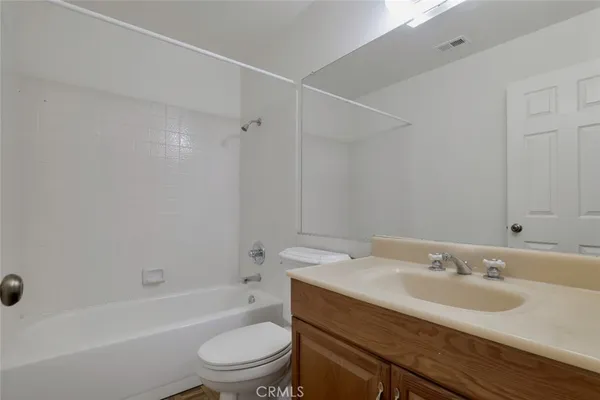 a bathroom with a granite countertop sink a toilet and shower