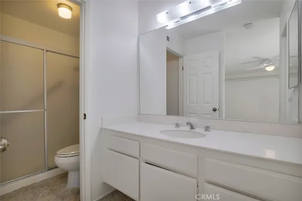 a bathroom with a sink a toilet a large mirror and shower