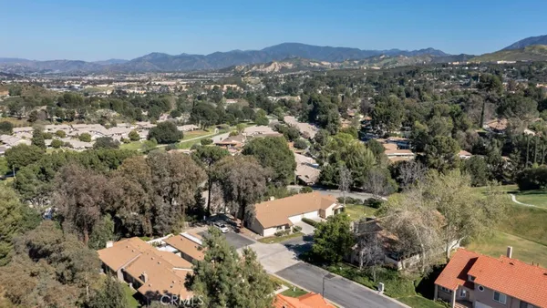 an aerial view of house with yard and mountain view in back