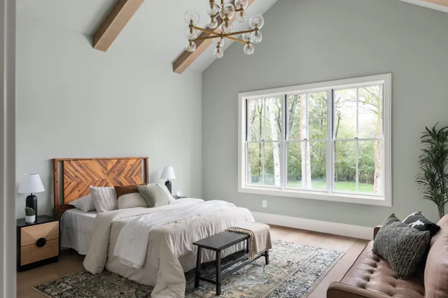 a bed sitting in a bedroom next to a window