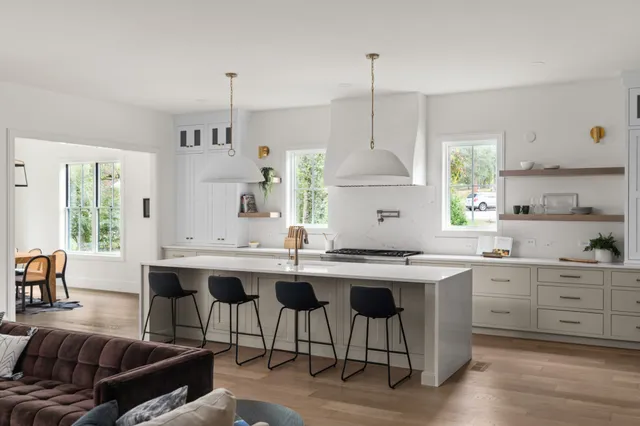 a kitchen with a sink a stove a dining table and chairs
