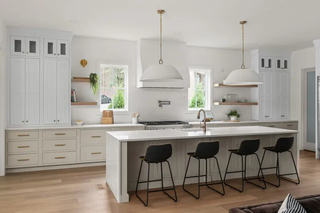 a kitchen with stainless steel appliances granite countertop a sink a stove and a window