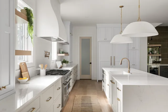 a kitchen with stainless steel appliances granite countertop a sink a stove and a wooden floors