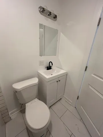 a white toilet sitting next to a bathroom sink