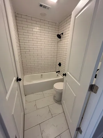 a bathroom with a bathtub and toilet