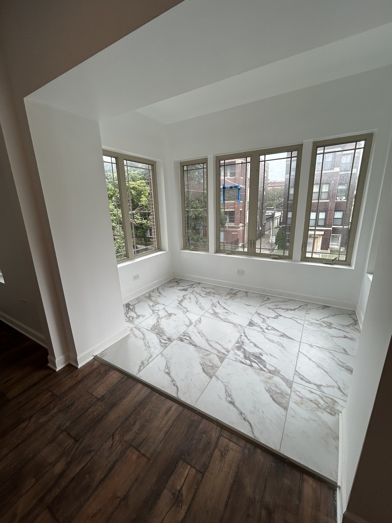 6016 South St Lawrence Avenue, Unit 1 Chicago, IL 60637 - Photo 6 of 16 a view of empty room with wooden floor and fan