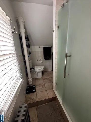 a spacious bathroom with a toilet a sink and a mirror