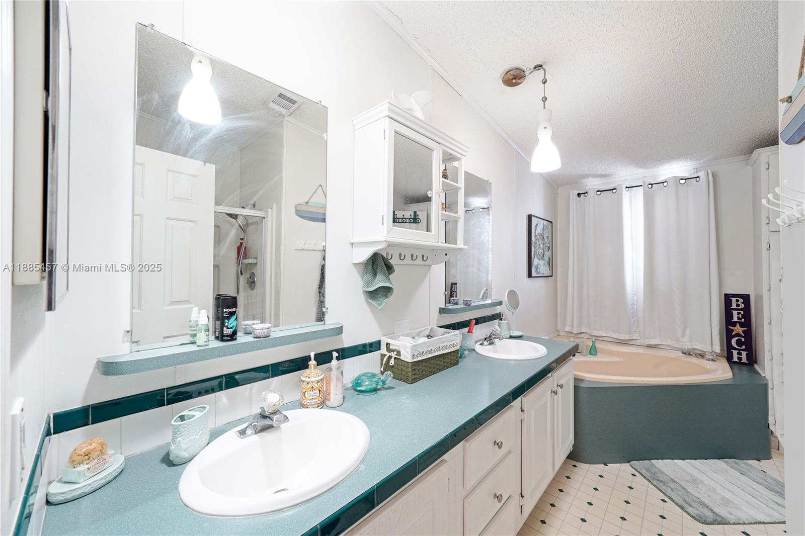 945 Plantation Road, Unit 945 Key Largo, FL 33037 - Photo 20 of 66 a bathroom with a double vanity sink large mirror and a bathtub