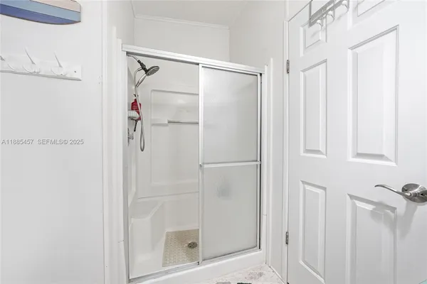 a bathroom with a glass door shower and a sink