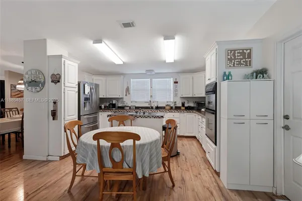 a kitchen that has a sink a stove and chairs