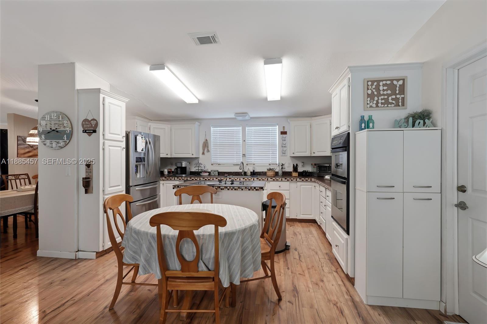 945 Plantation Road, Unit 945 Key Largo, FL 33037 - Photo 8 of 66 a kitchen with refrigerator a sink and chairs