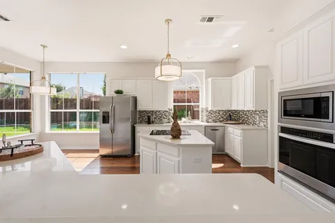 a kitchen with counter top space and windows
