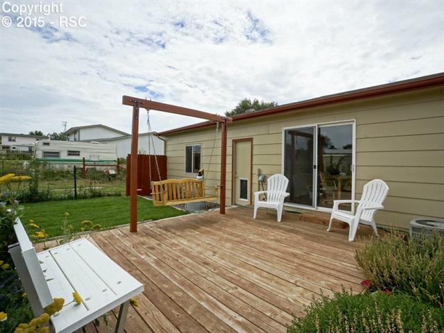 10850 Falling Star Road Fountain, CO 80817 - Photo 14 of 23 Wood patio off the kitchen with swing and bench.